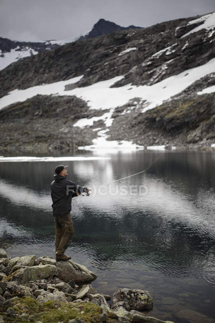 Side view of man fishing near Jotunheimen range — Stock Photo