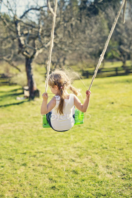 Rear view of girl on swing, selective focus — Stock Photo