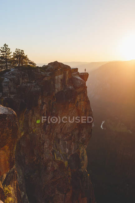 Vista panorámica del Parque Nacional Yosemite, hombre de pie en el borde de la roca en el fondo - foto de stock