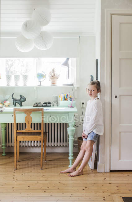 Mädchen lehnt an Wand im häuslichen Zimmer — Stockfoto
