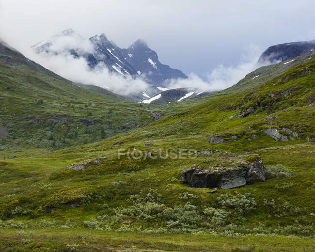 Jotunheimen range in clouds and green valley — Stock Photo