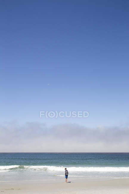 Ragazzo in piedi sulla spiaggia Carmel-by-the-Sea a Californa — Foto stock