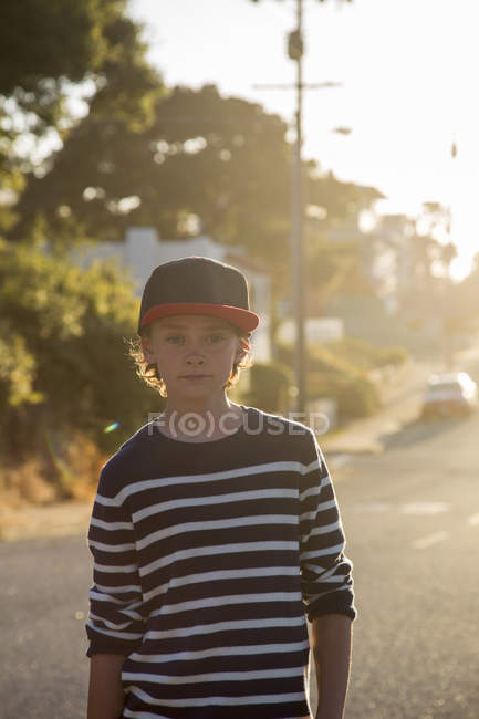 Porträt eines Jungen, der bei Sonnenuntergang im Pazifikhain auf der Straße steht, Kalifornien — Stockfoto