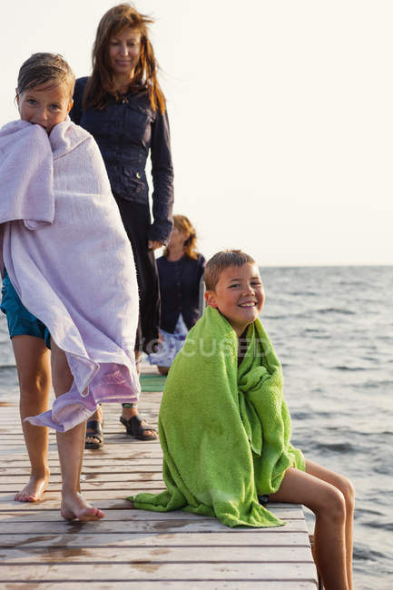 Children and mother on jetty, focus on foreground — Stock Photo