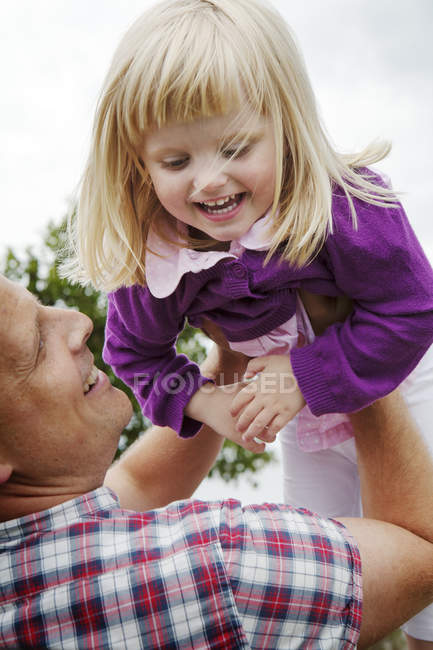 Father playing with daughter, focus on foreground — Stock Photo
