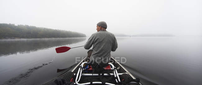 Вид ззаду людини, що веслує на озері — стокове фото