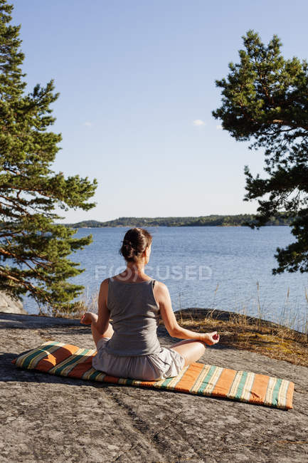 Rear view of woman meditating in forest — Stock Photo