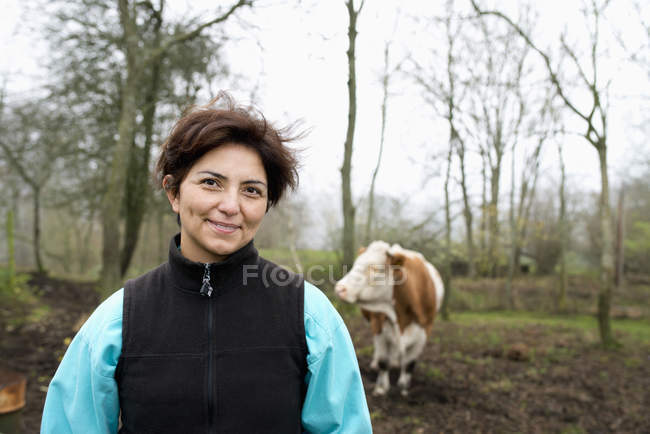 Portrait of female farmer, cows in background — Stock Photo