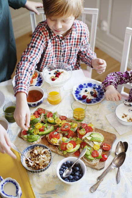 Мать с двумя детьми завтракает в столовой — стоковое фото