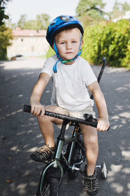 Портрет мальчика на трехколесном велосипеде, фокус на переднем плане — стоковое фото