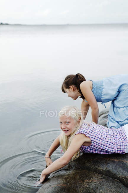 Vista lateral de duas meninas jogando à beira-mar — Fotografia de Stock