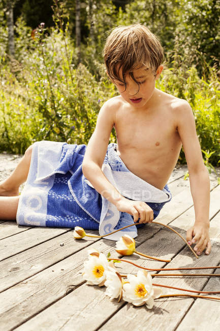 Portrait de garçon jouant avec des fleurs, mise au point sélective — Photo de stock