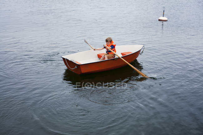 Хлопчик у червоному човні, вибірковий фокус — стокове фото
