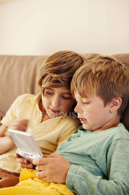 Brothers playing on game console, focus on foreground — Stock Photo
