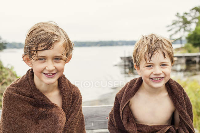 Портрет двух мальчиков, завернутых в полотенца, сфокусированных на переднем плане — стоковое фото