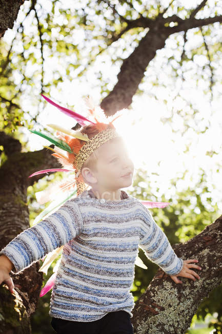 Boy wearing plume in sunlight, focus on foreground — Stock Photo