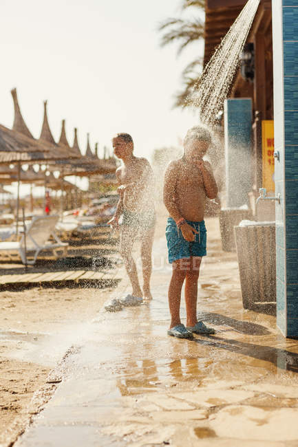 Ragazzi sotto la doccia sulla spiaggia di Minorca, Spagna — Foto stock