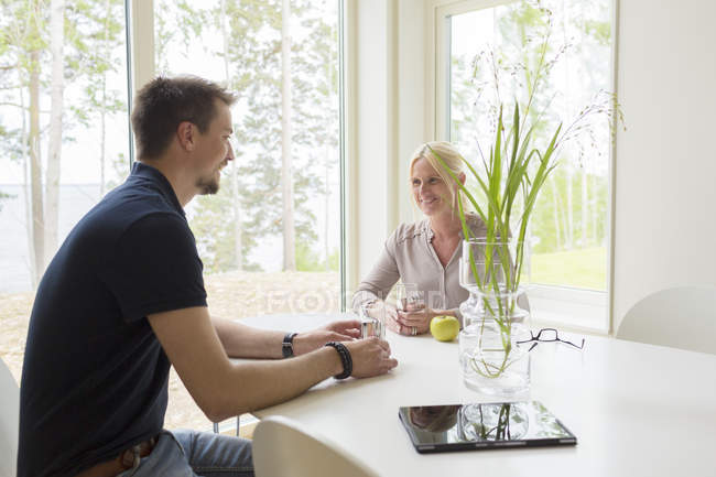 Homme et femme assis et buvant chez eux — Photo de stock