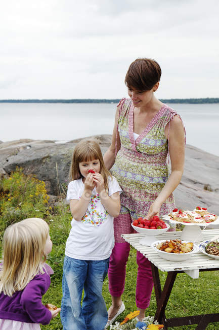 Donna che prepara tavolo da picnic al mare — Foto stock