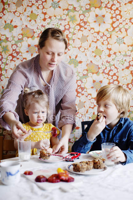 Мати з дочкою і сином їсть торт, вибірковий фокус — стокове фото