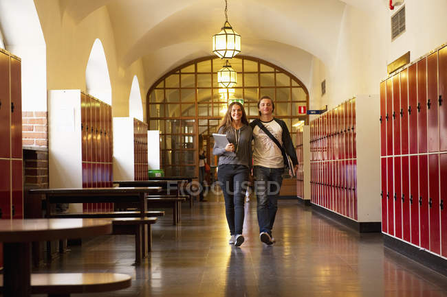 Estudiantes caminando en el pasillo escolar, enfoque selectivo - foto de stock