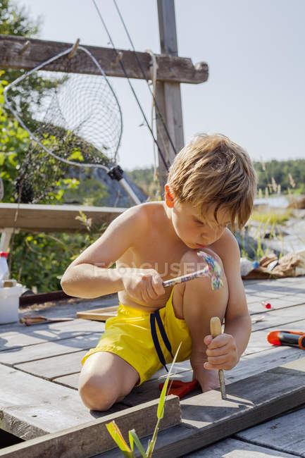 Хлопчик ремонтує дерев'яну палубу, вибірковий фокус — стокове фото