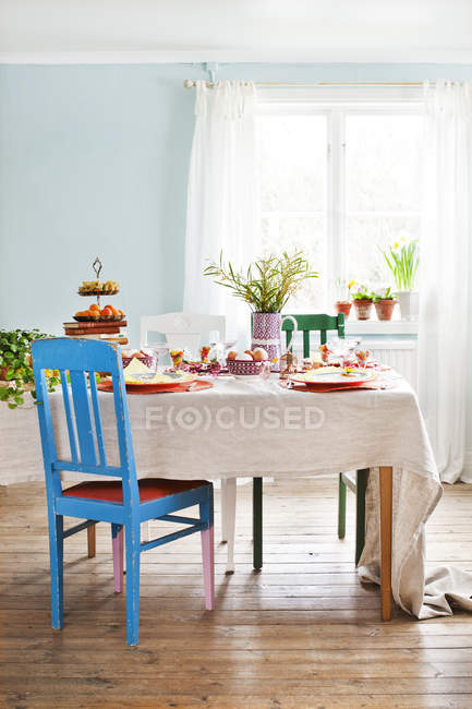 Sala de jantar com comida na mesa e cadeiras na Páscoa — Fotografia de Stock