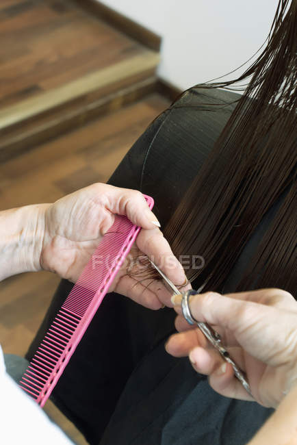 Hairdresser hands cutting hair, selective focus — Stock Photo