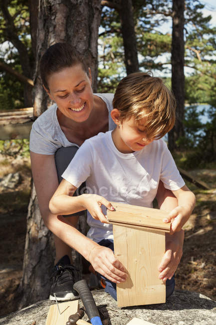 Mãe ajudando filho para construir birdhouse — Fotografia de Stock
