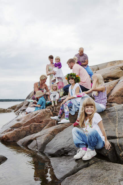 Grande família fazendo piquenique em rochas à beira-mar — Fotografia de Stock