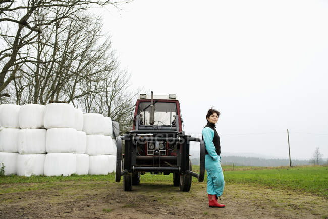 Portrait of farmer leaning against tractor — Stock Photo