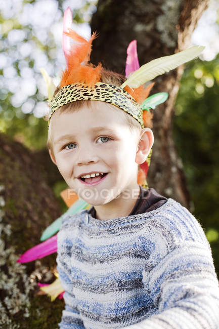 Портрет улыбающегося мальчика в короне, сфокусированного на переднем плане — стоковое фото