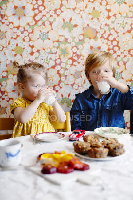 Niño y niña bebiendo leche, enfoque selectivo - foto de stock