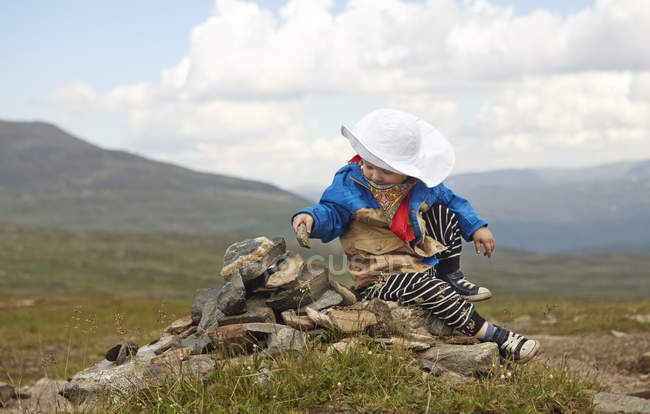 Boy sitting on cairn, selective focus — Stock Photo