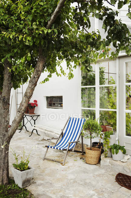 Striped sunlounger on patio at domestic garden — Stock Photo