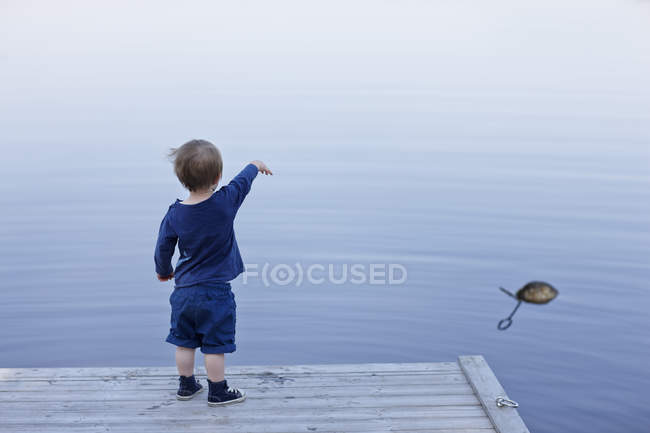 Rear view of boy standing on jetty — Stock Photo