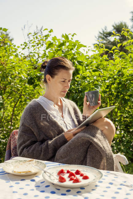 Frau nutzt im Sommer digitales Tablet draußen — Stockfoto