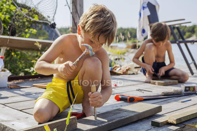 Мальчики ремонтируют деревянную палубу летом, избирательный фокус — стоковое фото