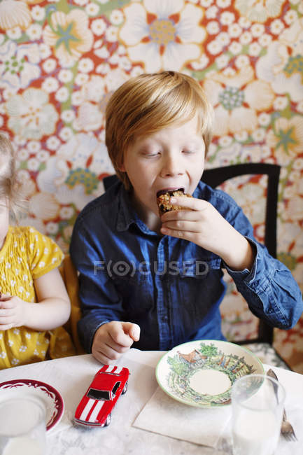 Niño y niña comiendo pastel, enfoque selectivo - foto de stock