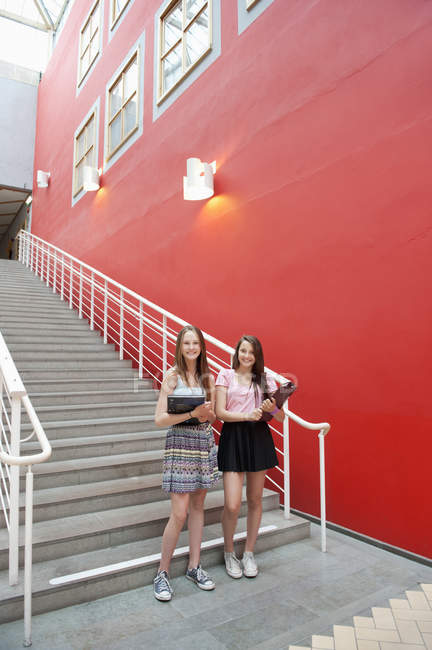 Porträt Teenager-Mädchen, die vor der Schule in die Kamera schauen — Stockfoto