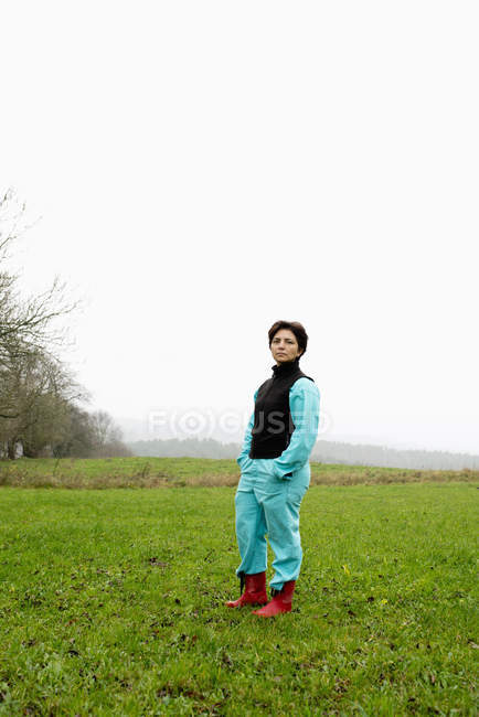 Ritratto di agricoltore in piedi in stivali di gomma sul campo — Foto stock