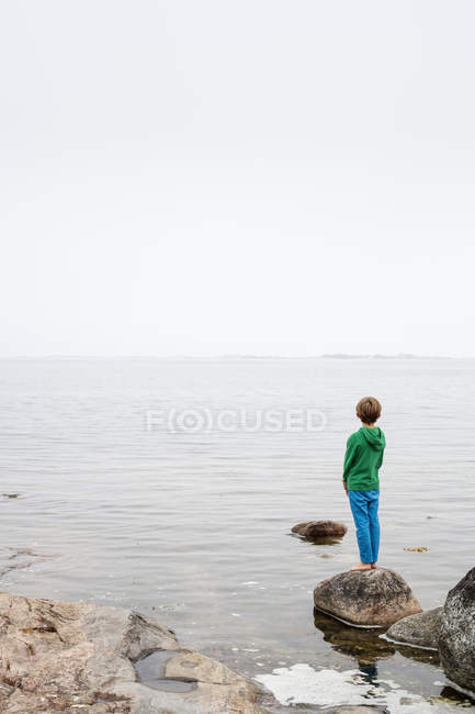 Вид ззаду хлопчика, що дивиться на море — стокове фото