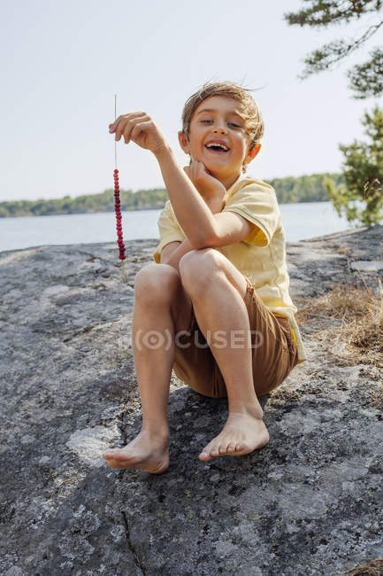 Retrato de menino segurando grama com bagas, foco seletivo — Fotografia de Stock
