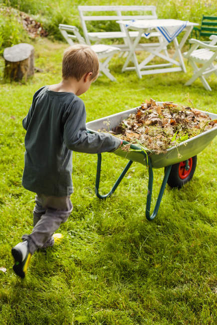 Boy pushing wheelbarrow, selective focus — Stock Photo