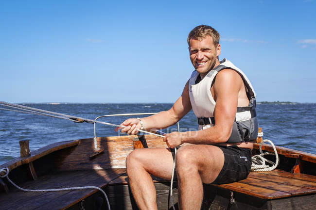 Mann segelt an sonnigem Tag und blickt in Kamera — Stockfoto