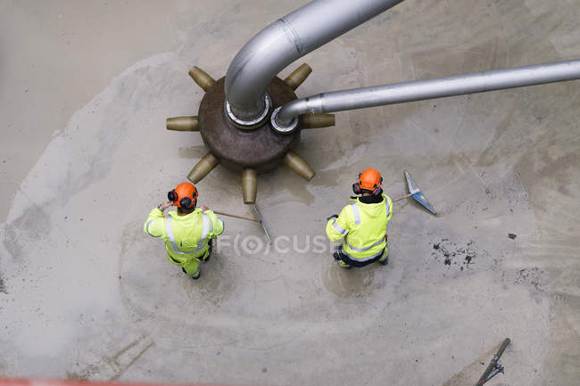 Two men in reflective clothing working at water treatment plant — Stock Photo