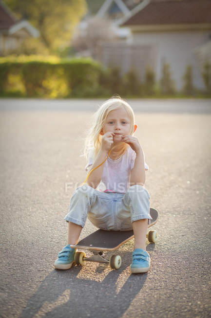 Portrait of girl on skateboard, selective focus — Stock Photo