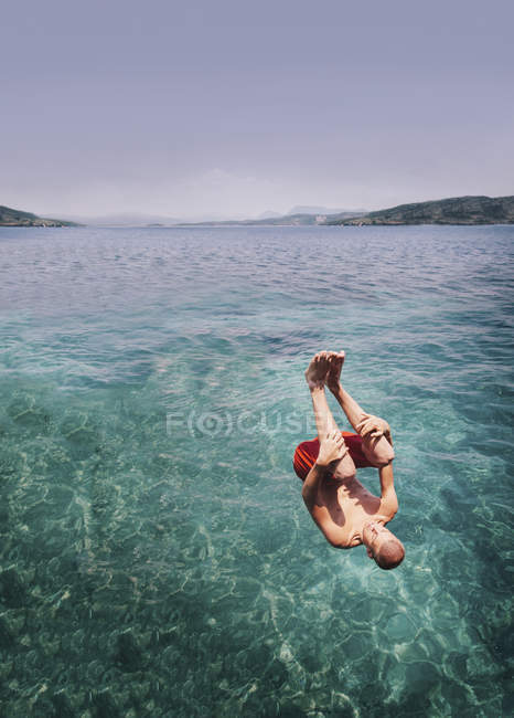Joven saltando al mar - foto de stock