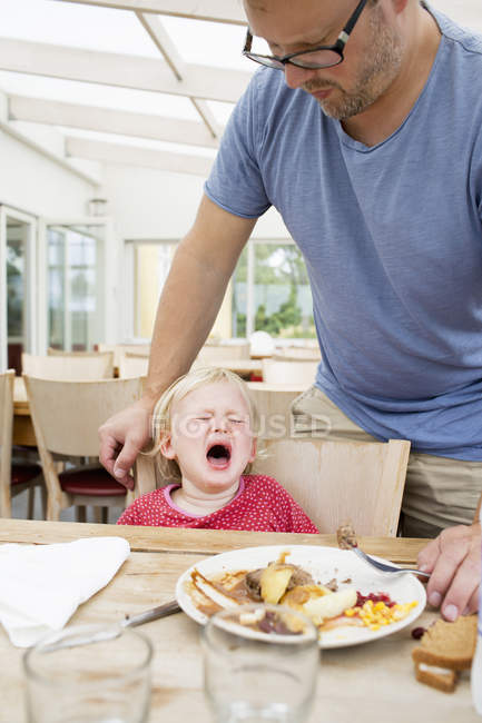 Young girl crying at dinner table — Stock Photo