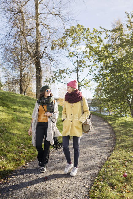 Two young women walking through footpath — Stock Photo